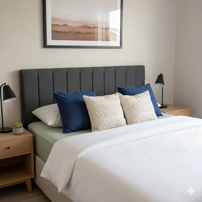 Bedroom with a bed featuring blue and beige pillows, two nightstands with lamps, and a framed picture on the wall.